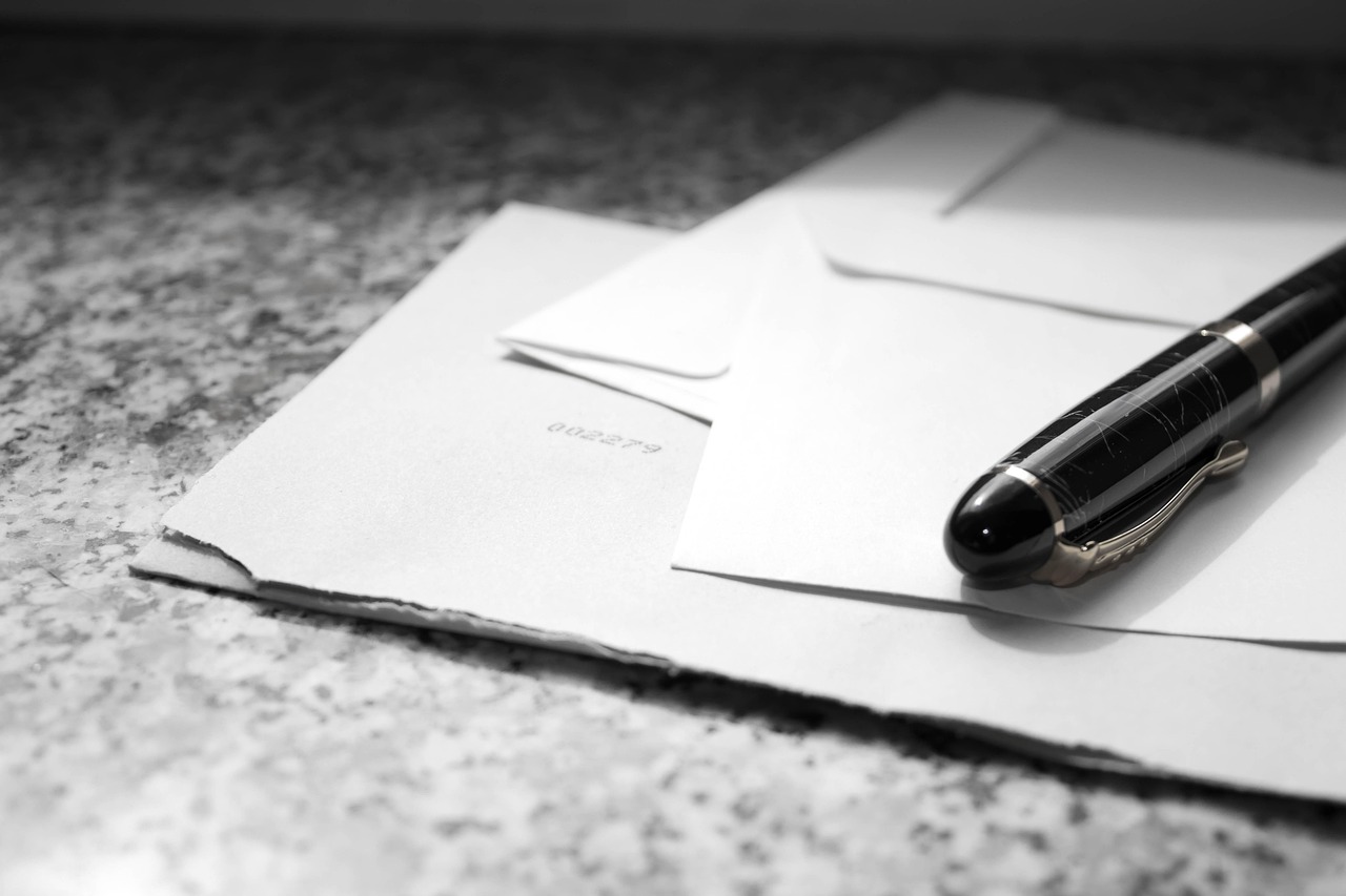 L'image montre une lettre et un stylo